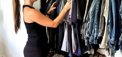 A woman organizing clothes in a closet.